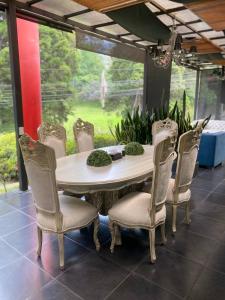 a dining room table and chairs with a large window at Hotel Aromax del Campestre in Medellín