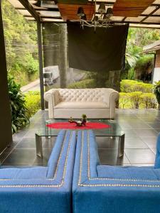 - un salon avec un canapé et une table en verre dans l'établissement Hotel Aromax del Campestre, à Medellín