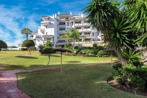 ein großes weißes Gebäude mit Palmen und einem Park in der Unterkunft calahonda cozy corner in Sitio de Calahonda
