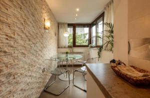 cocina con mesa de cristal y pared de ladrillo en Downtown Oasis Unirii Apartment en Bucarest