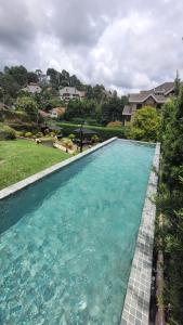 una piscina de agua azul en un patio en Secreto Boutique Hotel, en Campos do Jordão