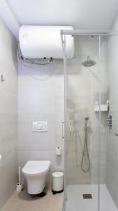 a white bathroom with a shower and a toilet at Juanito Fuengirola Apartment in Fuengirola