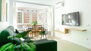 a living room with a green couch and a table at Juanito Fuengirola Apartment in Fuengirola