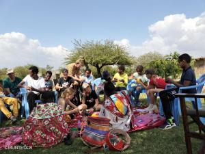 a group of people sitting in the grass at SEMADEP SAFARI CAMP in Sekenani