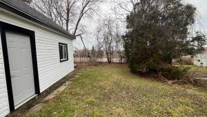 a yard next to a house with a garage at Renovated Home - Walk to Falls & Tourist District in Niagara Falls