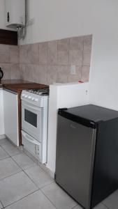 a kitchen with a stove and a refrigerator at Cabaña Yerba Buena in Carpintería