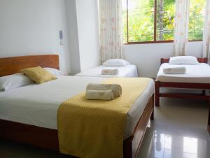 1 dormitorio con 2 camas y manta amarilla en Posada del Angel Hotel, en Tarapoto