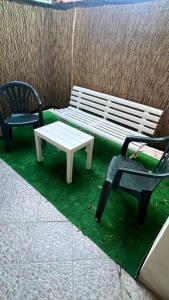 dos sillas y un banco y una mesa en Casa Corona - Appartamento affitto breve/lungo termine - casa vacanze, en Terralba