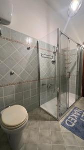 y baño con aseo y ducha acristalada. en Casa Corona - Appartamento affitto breve/lungo termine - casa vacanze, en Terralba