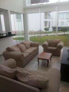 ein Wohnzimmer mit 2 Sofas und einem Couchtisch in der Unterkunft CONDOMINIO MORAVIA 2 33 in Bujama Baja