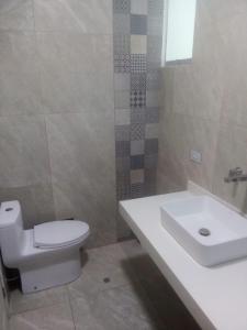 ein Badezimmer mit einem weißen WC und einem Waschbecken in der Unterkunft CONDOMINIO MORAVIA 2 33 in Bujama Baja