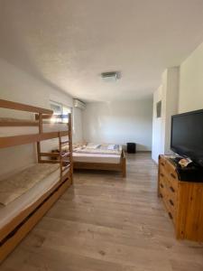 a room with two bunk beds and a flat screen tv at Villa Mimoza Blagaj in Blagaj