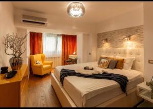 um quarto com uma cama grande e uma cadeira amarela em Downtown Oasis Unirii Apartment em Bucareste