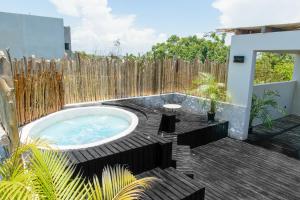 a hot tub in a backyard with a wooden fence at Che Suites Tulum in Tulum