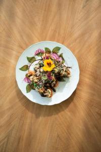 une assiette blanche avec salade sur une table en bois dans l'établissement Hotel Gletscherblick, à Hasliberg