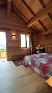a bedroom with a bed in a wooden cabin at Les Cabris in Pelvoux