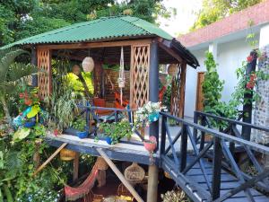 Hostal Antawara Tayrona في الزينو: شرفة خشبية عليها نباتات