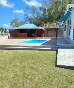 une maison avec une piscine dans une cour dans l'établissement Superbe villa, à Bouillante