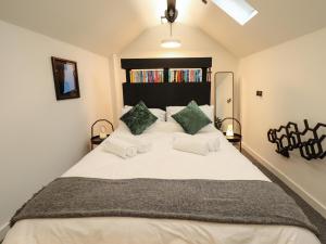 a bedroom with a large white bed with green pillows at The Pump House Forge in Doncaster