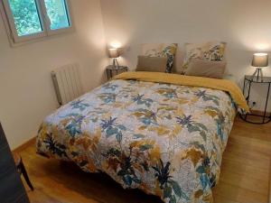 una camera da letto con un letto con un piumone colorato di Gîte à la ferme a Questembert
