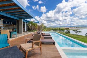 een buitenterras met stoelen en een zwembad bij @morro.redondo - A casa Azul e seu Pôr do Sol in CÃ¡ssia