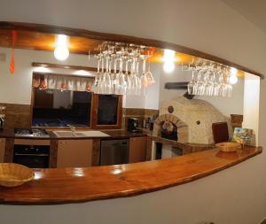 une cuisine avec un comptoir avec des verres suspendus au-dessus dans l'établissement Vila Decebal, à Râșnov