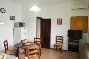 a kitchen and dining room with a table and a television at Apartamentos rurales Entrecaminos in Ardales