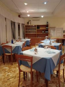 een kamer met tafels en stoelen met blauwe tafelkleden bij Hotel San Paolo in Varazze