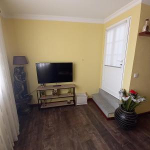 ein Wohnzimmer mit einem Flachbild-TV an einer gelben Wand in der Unterkunft Casa da Fonte in Peso da Régua