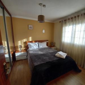 ein Schlafzimmer mit einem großen Bett und zwei Fenstern in der Unterkunft Casa da Fonte in Peso da Régua