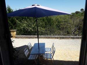 a table and chairs under a blue umbrella at Les hyacinthes in Sarlat-la-Canéda