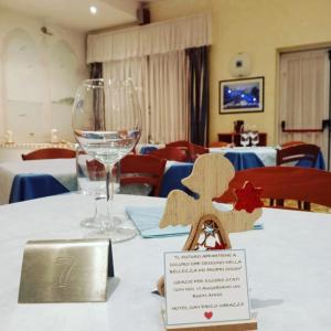 a table with a wine glass and a sign on it at Hotel San Paolo in Varazze