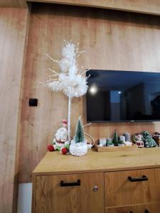 un árbol blanco de Navidad sentado en la parte superior de un tocador en Apartman Lenka Villa Mont Jahorina, en Jahorina