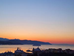 uma vista para o pôr-do-sol de uma cidade e da água em Lavinia Apartment em La Spezia
