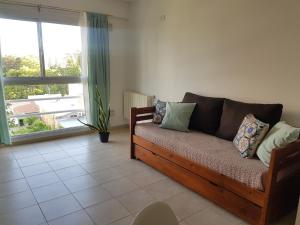 a living room with a couch and a large window at Departamento Talero con cochera in Neuquén