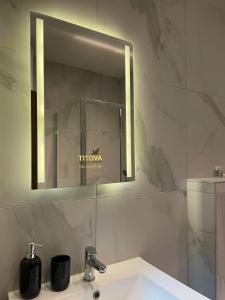 ズラティボールにあるMagnum apartment Titova vilaの洗面台と鏡のあるバスルーム