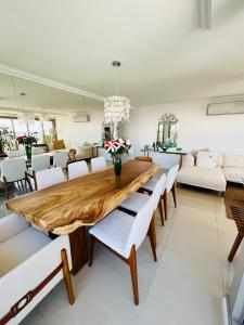 comedor con mesa de madera y sillas blancas en Imperialeluxuryapartment en Punta del Este