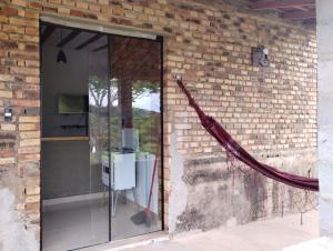 a glass door on the side of a brick wall at Bangalô Alto da Pedreira in Socorro