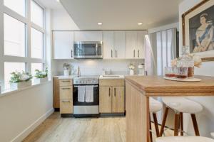 a kitchen with white cabinets and a wooden counter top at Victoria's Parliamentary Suite with Private Rooftop Patio & Harbour View in Victoria
