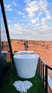 a bath tub on a balcony with a view of a desert at Marbella bungalows desert in Bidiyah