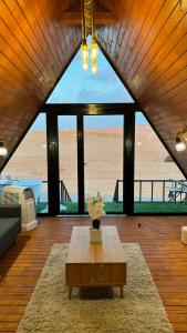 a living room with a table and a view of the ocean at Marbella bungalows desert in Bidiyah