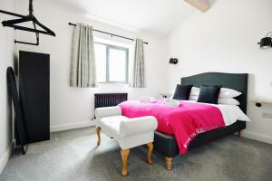 a bedroom with a large bed with a pink blanket at Ingleborough Lodge in Settle