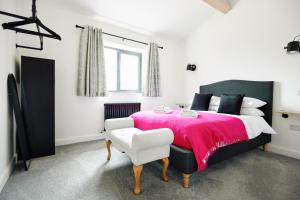 Un dormitorio con una cama grande con una manta rosa. en Ingleborough Lodge, en Settle