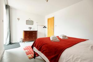 um quarto com uma cama com um cobertor vermelho em Penyghent View em Rathmell