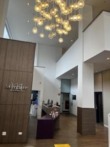 a large lobby with a chandelier in a building at Flat Hotel Mercure - 4 Estrelas Moema SP in Sao Paulo