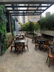a group of tables and chairs on a patio at Flat Hotel Mercure - 4 Estrelas Moema SP in Sao Paulo
