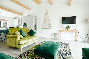 a living room with a green couch and a christmas tree at Whernside Lodge in Settle