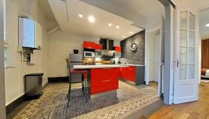 a kitchen with red cabinets and a red counter top at Appartement tout équipé - Centre-ville EPERNAY in Épernay +20 photos