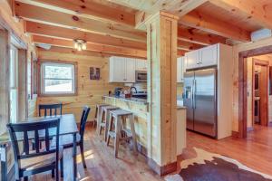 a kitchen with a table and a refrigerator at Forested Ellijay Cabin Rental with Private Hot Tub! in Ellijay