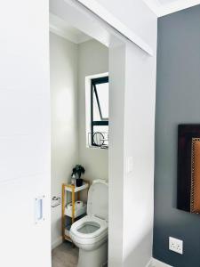 a bathroom with a white toilet and a mirror at Feel at Home Mbombela Self Catering in Nelspruit